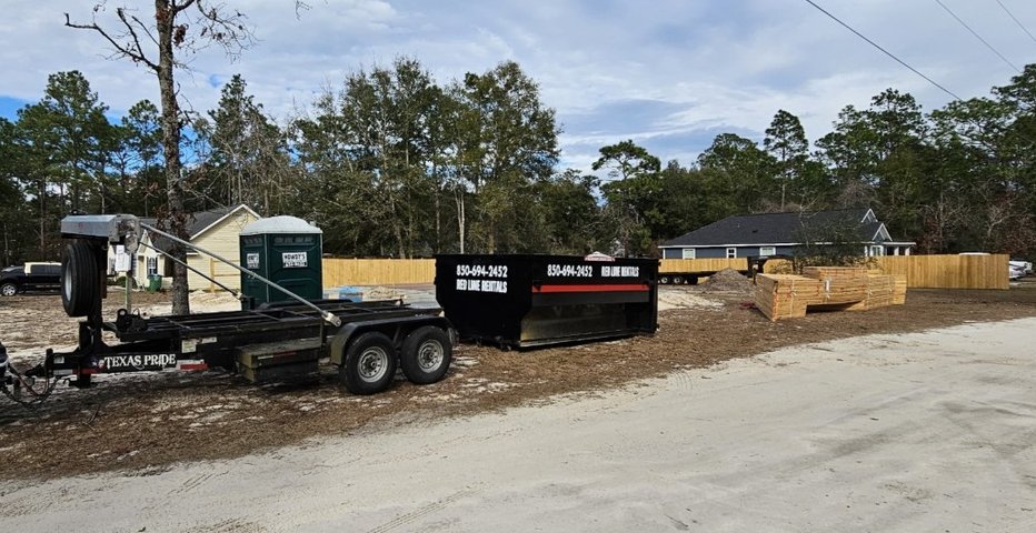 Red Line Rentals roll-off dumpster and dump trailer at a residential construction site